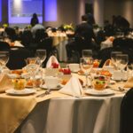 A beautifully arranged dining table set for an elegant banquet or event inside a restaurant.